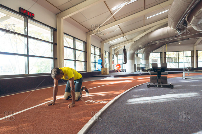 Disabled African American male relaxing on a running track in fitness center