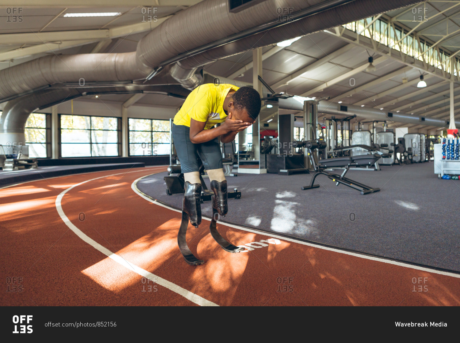 Disabled African American male athletic disappointed after losing race in fitness center
