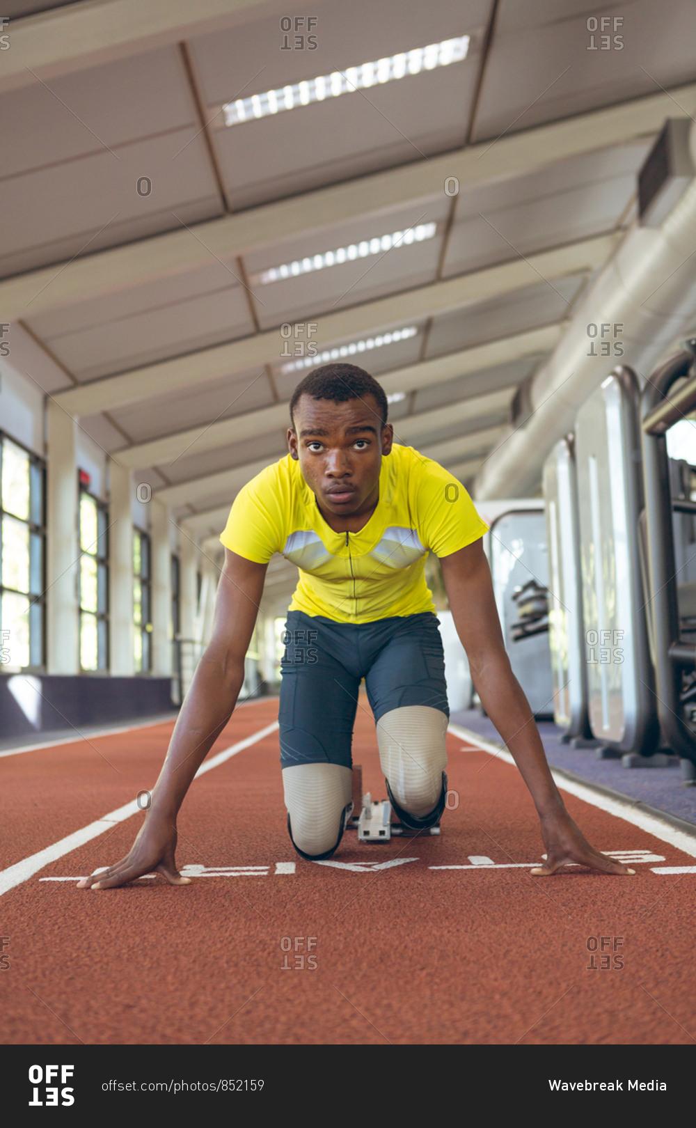 Disabled African American male athletic at starting point on running track in fitness center