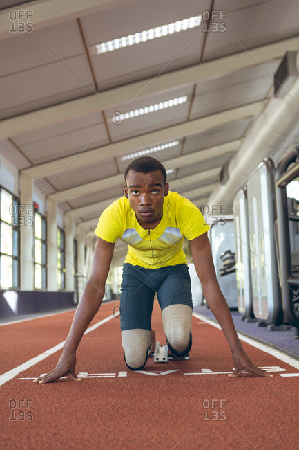 Disabled African American male athletic at starting point on running track in fitness center