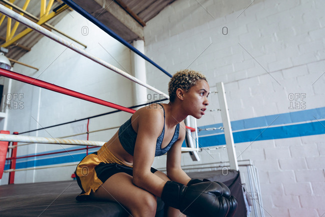 Female boxer resting in boxing club