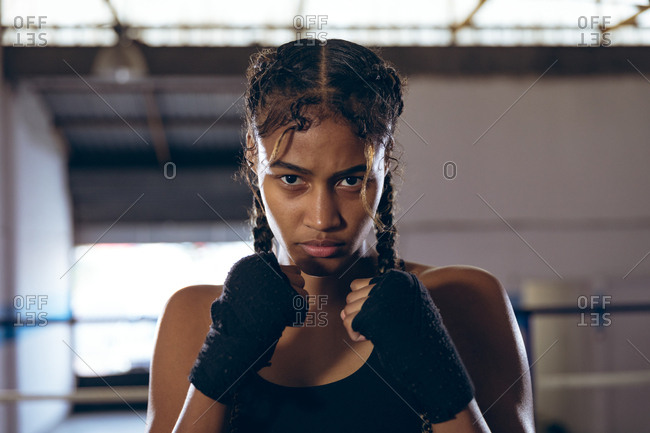 Female boxer with fist looking at camera in boxing club