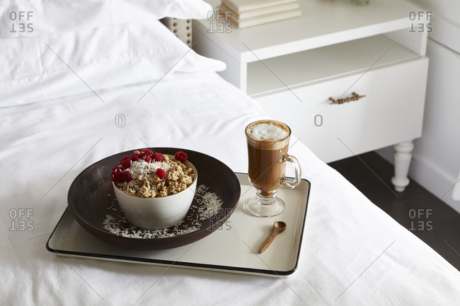 Granola with fresh raspberries and hot cocoa served on a bed