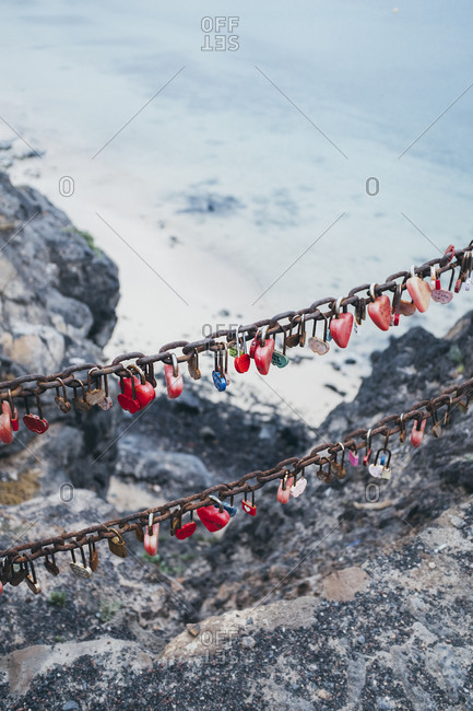 Love locks on chain above sea water in spain