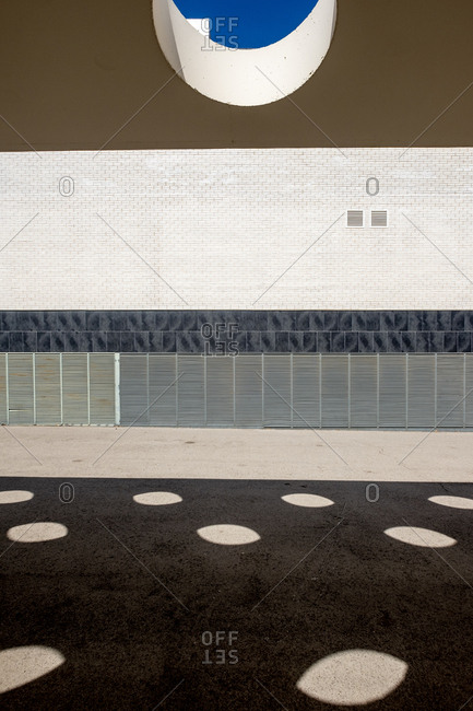 Facade of a modern building and a wall with circular holes in an area of ??modern architecture