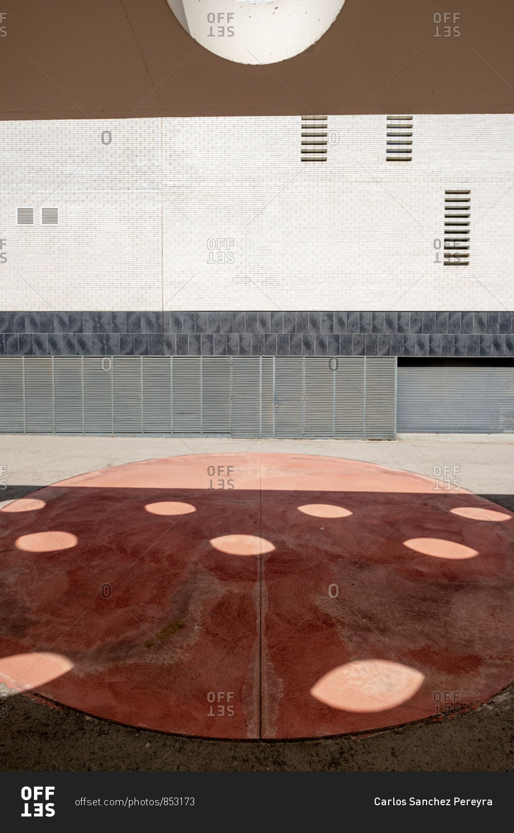 Facade of a modern building and a wall with circular holes in an area of ??modern architecture