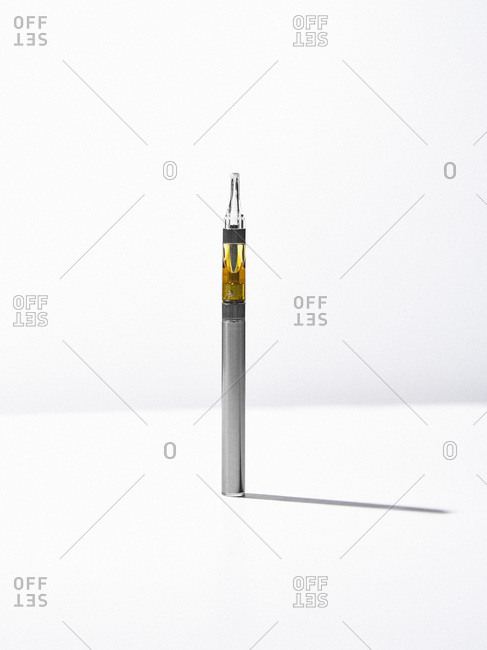 Full marijuana oil cartridge in a vaporizer pen on a white background.