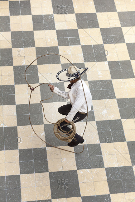 A young man dressed as a charro jumps the rope on the floor of a patio in Lagos de Moreno, Jalisco.