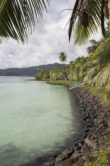 Small artificial blue water bay with palm trees, Samoa