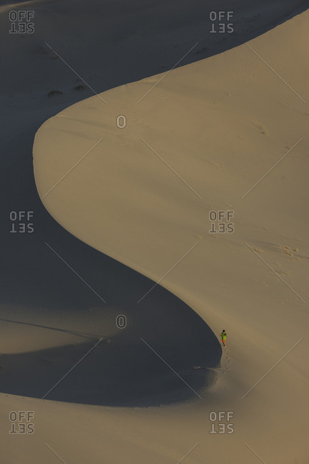 Boy, age 9 running along the spine of a sand dune in the desert
