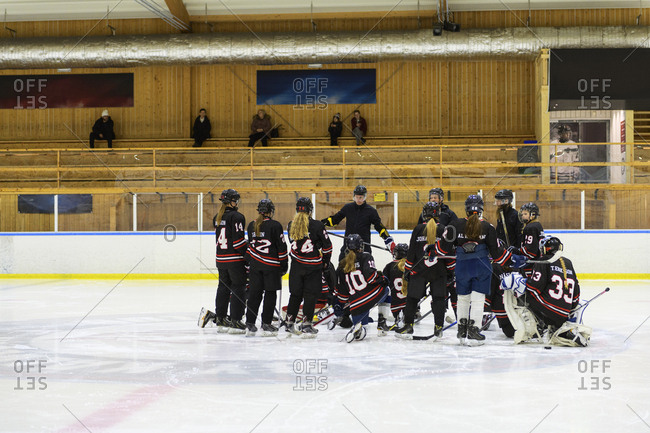 Girls listening to their coach during ice hockey training