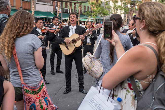 July, 23, 2019: A mariachi band plays in front of some tourists in Garibaldi Square, Ciudad de Mexico, Mexico