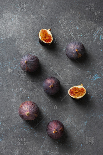 Organic sliced and whole fresh figs on dark background