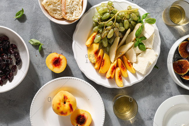Various fruit wine snacks with cheese and olives overhead view