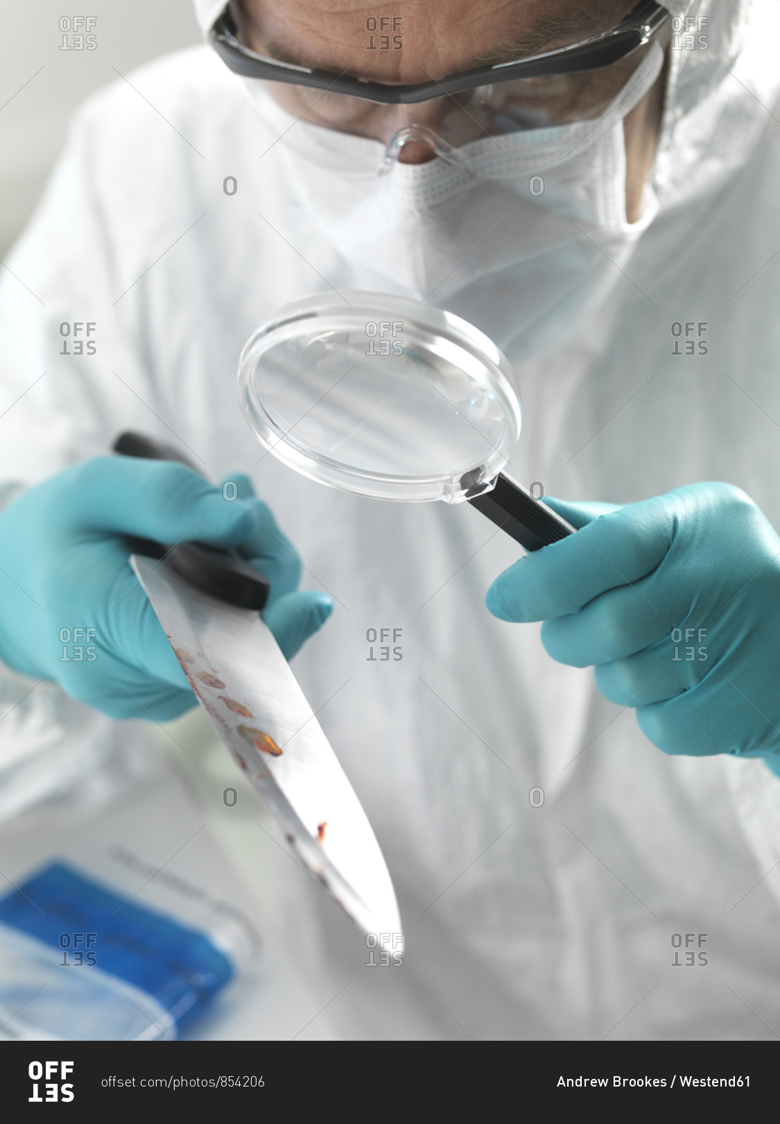 Forensic scientist examining a knife taken from a violent crime scene in the laboratory