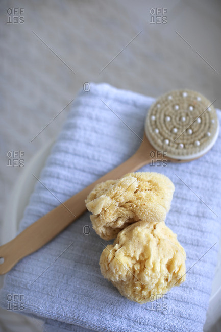 Bath sponges and scrub brush on a blue towel
