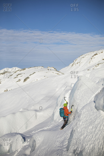 Man ice climbing on glacial seracs in the coast mountain range.