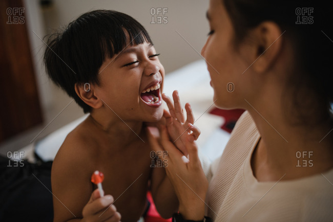 Asian boy and sister laughing in a room