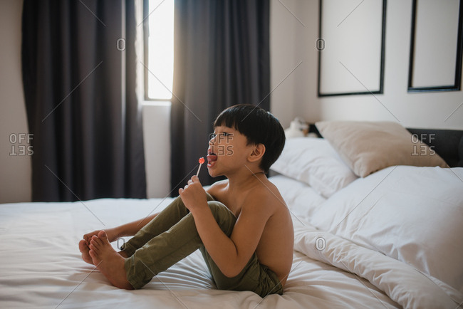 Asian boy eating lollypops