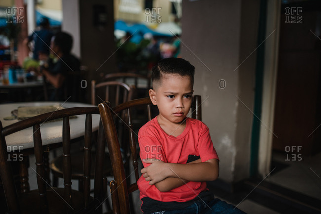 Asian boy sitting on a chair