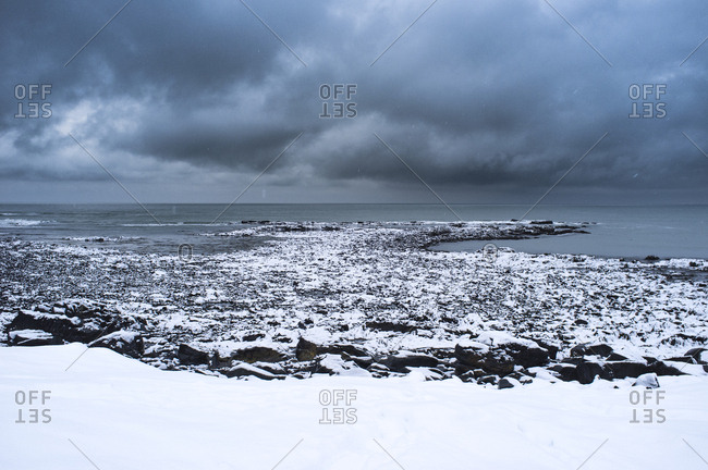Snow covered rocks as a winter storm moves offshore