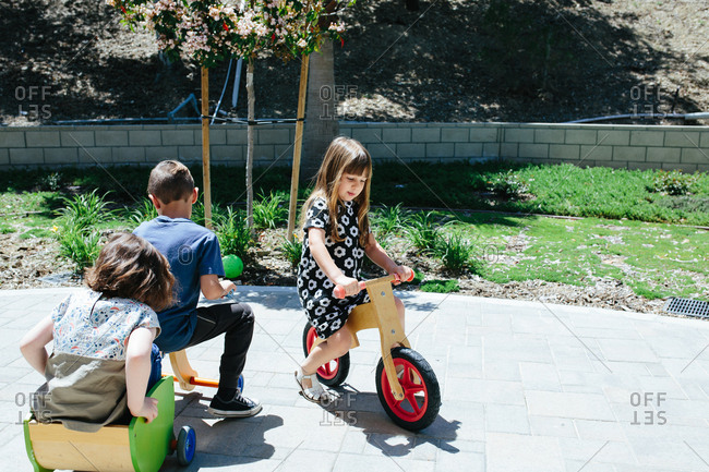 Kids outside play on wooden bicycles