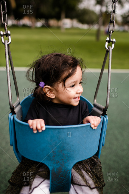 Little girl sitting in swing smiling