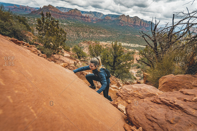 Female trail runner scrambling cathedral rock