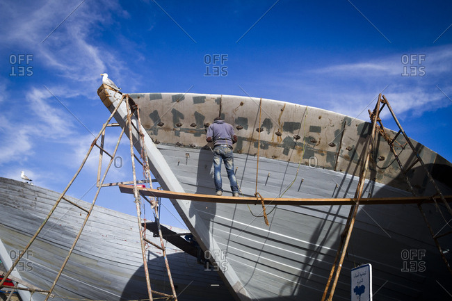 March 28, 2013: Repairing a boat at the harbor in Essaouira, Morocco, Africa