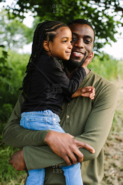 A portrait of a dad holding his daughter
