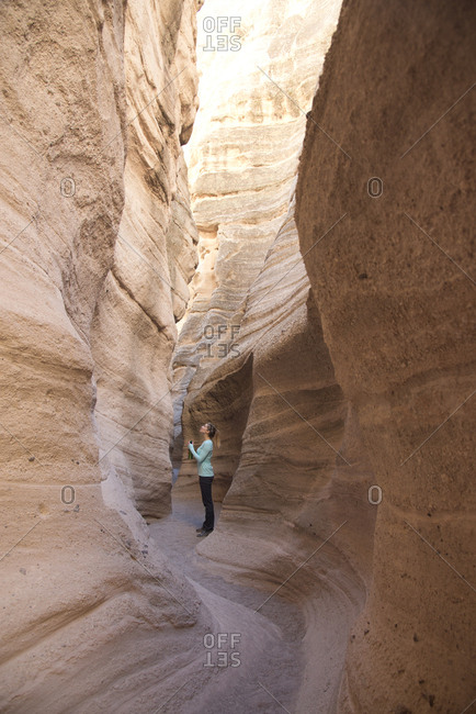 Woman admiring a sandstone slot canyon in Kasha-Katuwe Tent Rocks National Monument, New Mexico