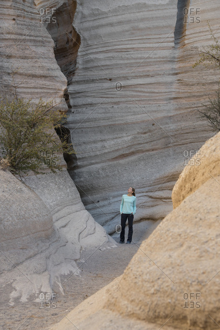 Woman looking up at a sandstone slot canyon in Kasha-Katuwe Tent Rocks National Monument, New Mexico