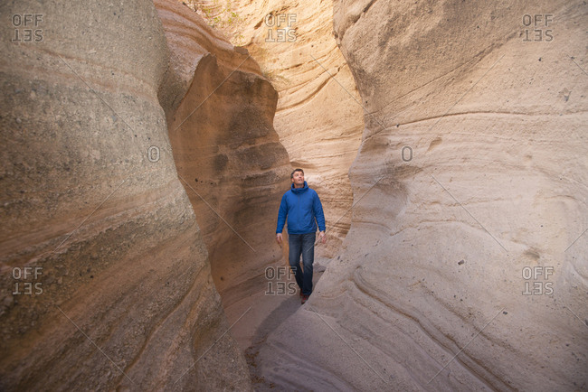Man admiring a sandstone slot canyon in Kasha-Katuwe Tent Rocks National Monument, New Mexico