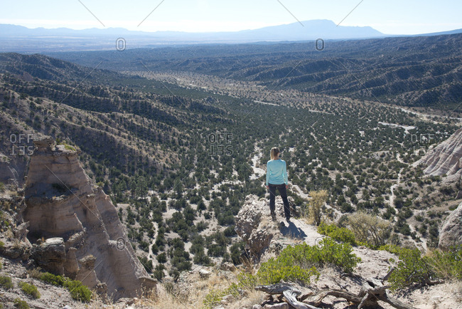 Woman standing on a bluff looking out over Kasha-Katuwe Tent Rocks National Monument, New Mexico