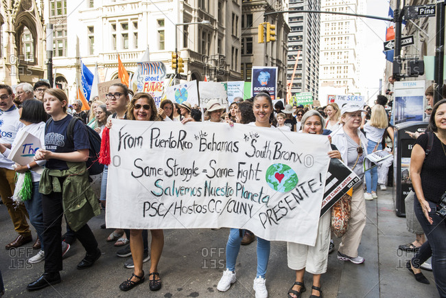 New York City, New York - September 20, 2019: Women holding a large banner while marching at the Global Climate Strike