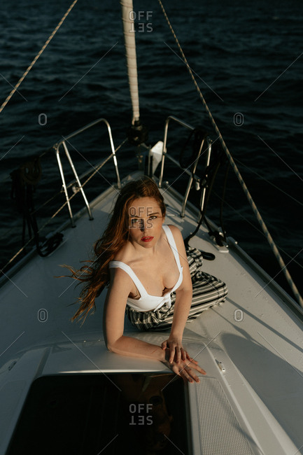 Appealing and attractive redhead lady looking at camera enjoying while traveling on ship