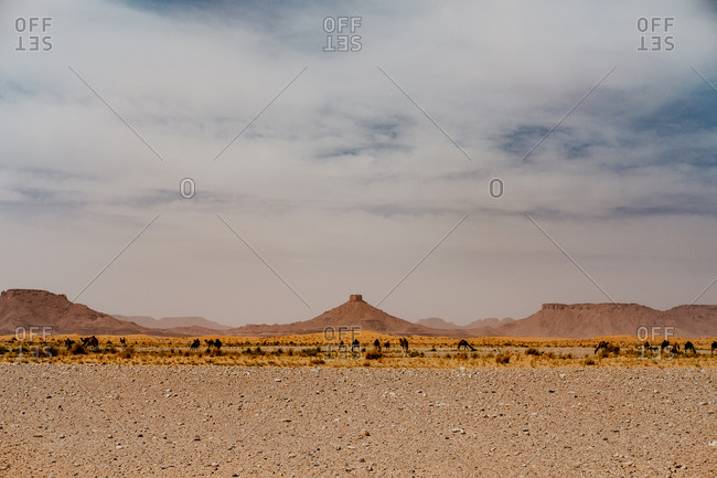 Cloudy sundown sky over hills and rocks in arid desert in evening in morocco