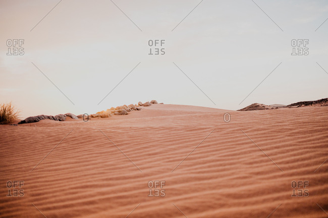 Cloudy sundown sky over hills and rocks in arid desert in evening in morocco