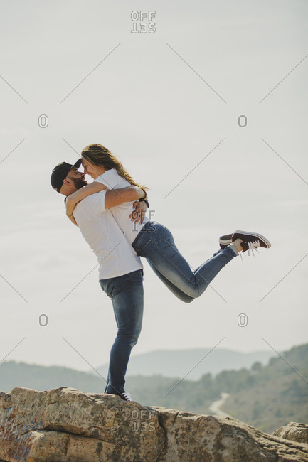 Loving couple embracing while standing at mountain cliff