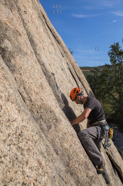 Man climbing a rock in nature with climbing equipment