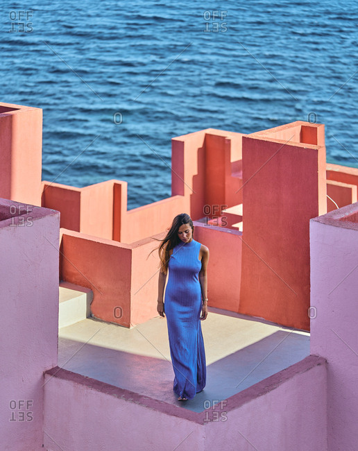 From above of woman in blue fur dress on the roof of a building