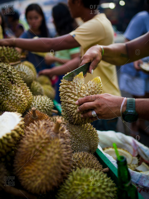 Market seller cutting a durian