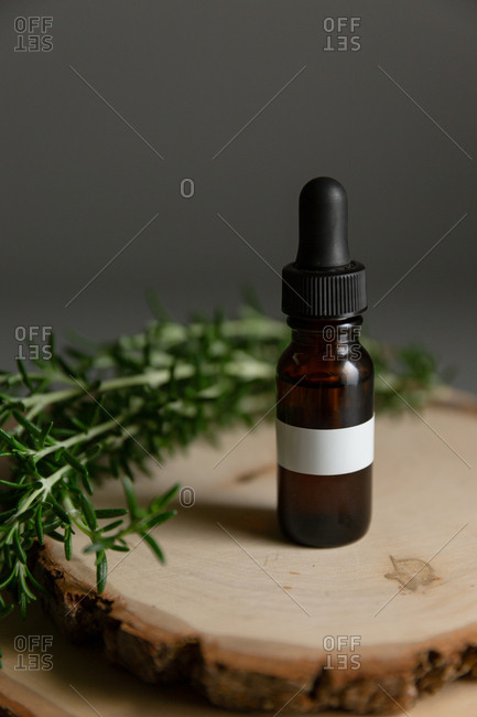 Essential oil bottle surrounded by rosemary