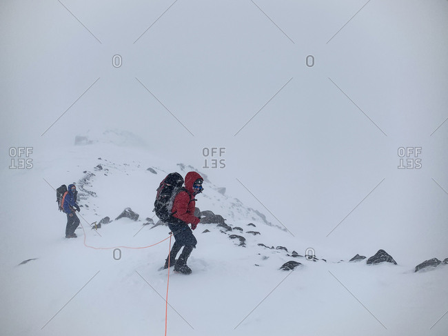 Mount Rainier National Park, Washington, United States - May 26, 2019: Climbers brave the elements as they descend to camp muir