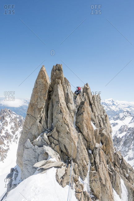 A seasoned alpinist rappels a spectacular gendarme on the forbes ridge