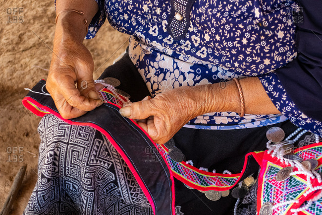 Woman making traditional garments, Vang Vieng, Laos