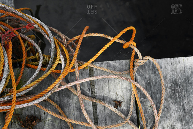 Old worn nautical boat ropes on weathered wooden jetty