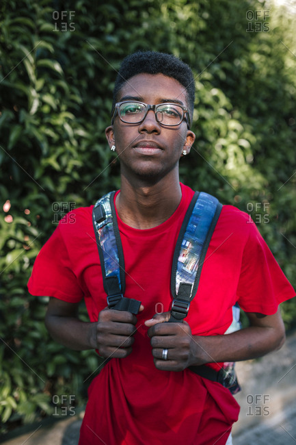 Young black student with backpack and glasses
