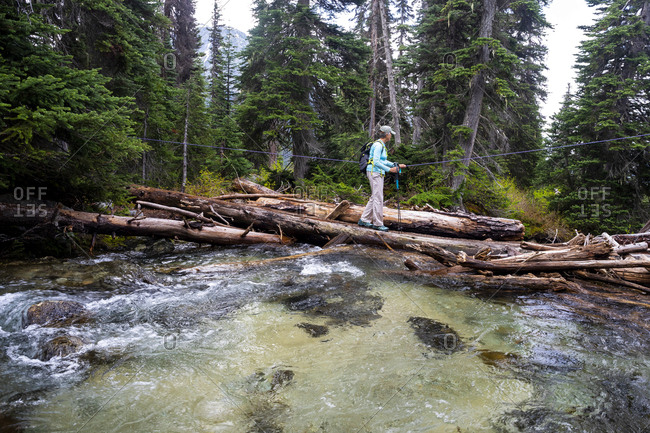 Mid length view of women hiking across a river in british columbia.