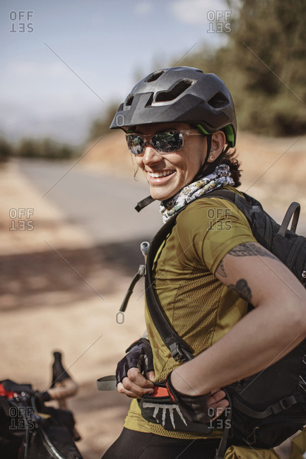 Morocco, Marrakesh-Safi - April 3, 2019: A female cyclist wearing sunglasses smiles while stopped on the road